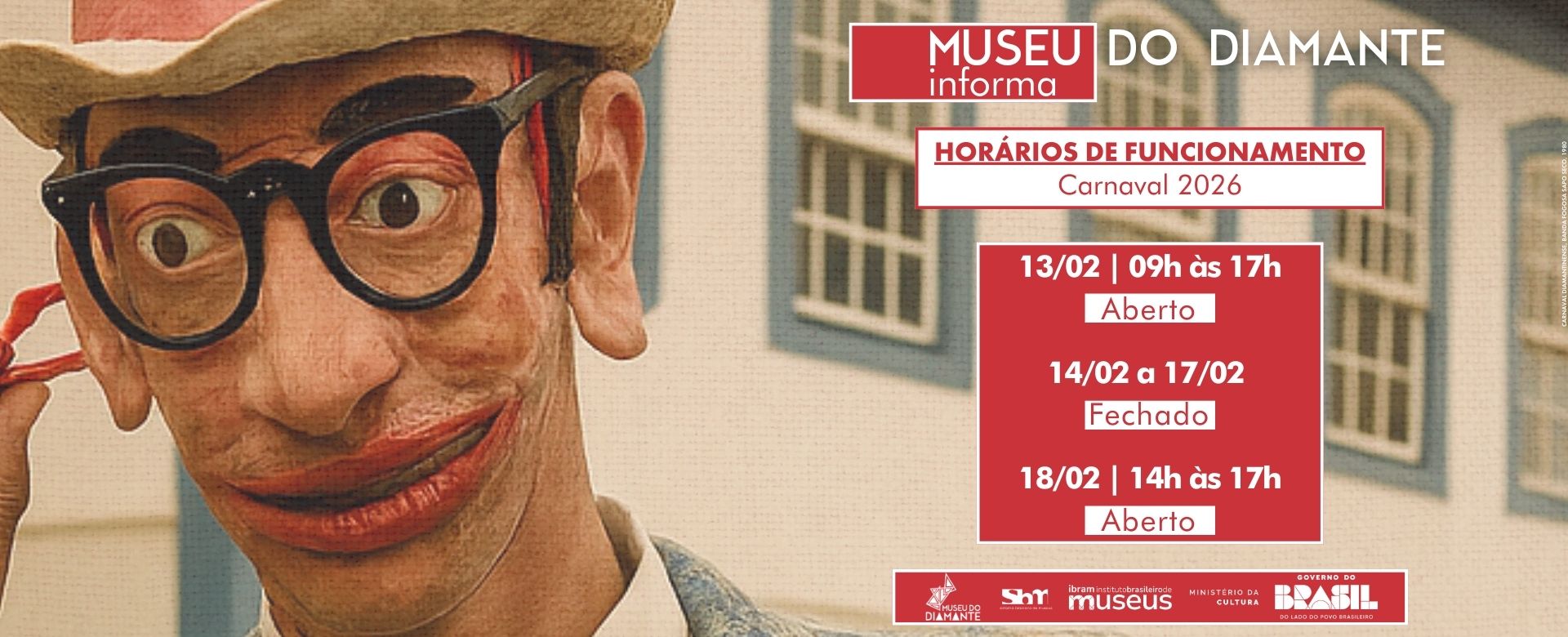Card informativo do Museu do Diamante sobre os horários de funcionamento no Carnaval 2026. O fundo mostra parte de uma figura mascarada trajando roupa antiga, com paletó claro e camisa branca, em frente a uma fachada colonial azul e branca. No centro, há uma caixa com o título “Horários de Funcionamento – Carnaval 2026”. Abaixo, três avisos em destaque: “13/02 | 09h às 17h – Aberto”, “14/02 a 17/02 – Fechado” e “18/02 | 14h às 17h – Aberto”. No rodapé, aparecem logomarcas do Museu do Diamante, Sistema Brasileiro de Museus, Instituto Brasileiro de Museus, Ministério da Cultura e Governo Federal.