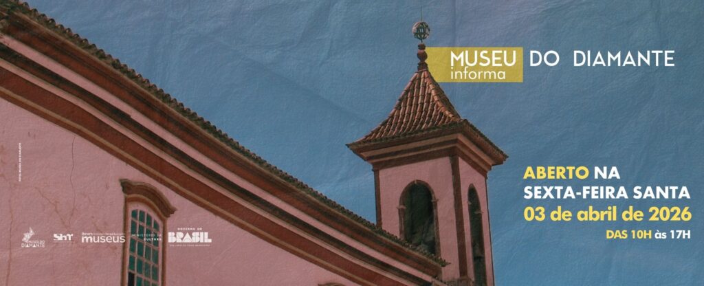 Card informativo do Museu do Diamante com fundo azul‑acinzentado. No topo direito, lê-se “Museu do Diamante informa”. O texto principal anuncia: “Aberto na Sexta‑Feira Santa — 03 de abril de 2026”, seguido do horário: “das 10h às 17h”. À esquerda, aparece parte de uma edificação histórica com fachada clara, telhado de telhas cerâmicas e uma torre com sino e ornamento no topo, sob céu azul. Na parte inferior esquerda, estão as logomarcas do Museu do Diamante, do Sistema Brasileiro de Museus, do Instituto Brasileiro de Museus, do Ministério da Cultura e do Governo Federal do Brasil.