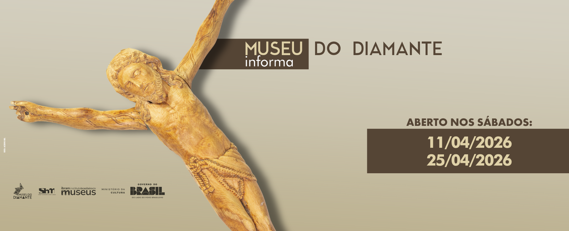 Card informativo do Museu do Diamante, com fundo claro. No canto superior direito, lê‑se “Museu do Diamante informa”. Ao centro, há uma escultura sacra antiga em marfim, representando a figura de Cristo com braços abertos, esculpida em tons de amarelo e marrom. Na parte inferior, o texto informa: “Aberto nos sábados: 11/04/2026 e 25/04/2026”. No rodapé, aparecem as logomarcas do Museu do Diamante, do Sistema Brasileiro de Museus, do Instituto Brasileiro de Museus, do Ministério da Cultura e do Governo Federal do Brasil.